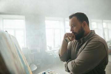 Focused male painter working on a new artwork