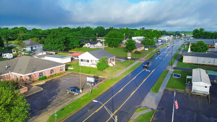 West Gentry Avenue in downtown Checotah, small town in McIntosh County, Oklahoma, mix of commercial buildings, churches, schools, residential neighborhood large houses, lush green trees, aerial