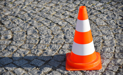 Traffic cone on a cobblestone road