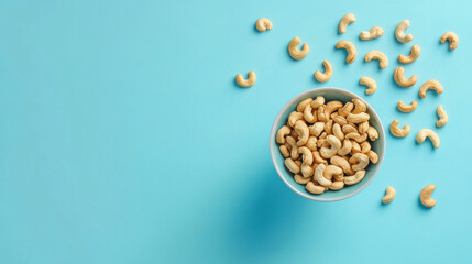 Cashew nuts in a bowl, floating, blue background, clean.
