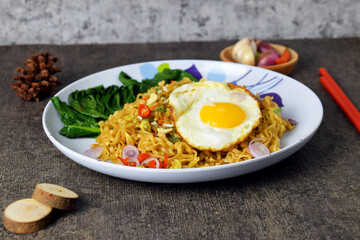 Closeup photo of fried noodles with sunny side up egg on a plate