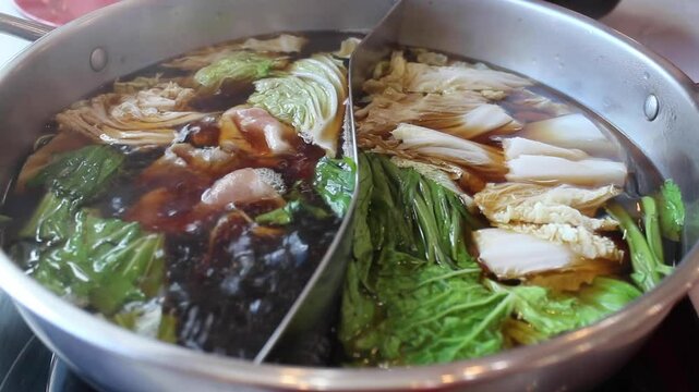 Hand holding pork using chopsticks on shabu or sukiyaki hotpot, stock footage