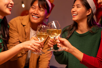 A group of people are celebrating a holiday by toasting with wine glasses