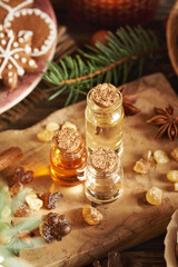 Fototapeta premium Christmas still life with bottles of essential oils with frankincense, spruce tree, cinnamon and star anise