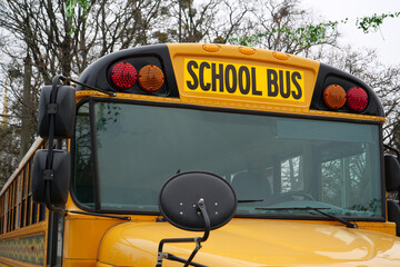 School bus stands in parking lot near the school in USA