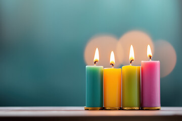 Four lit advent candles in vibrant colors on a table with a soft bokeh background, symbolizing Christmas traditions and spiritual reflection.