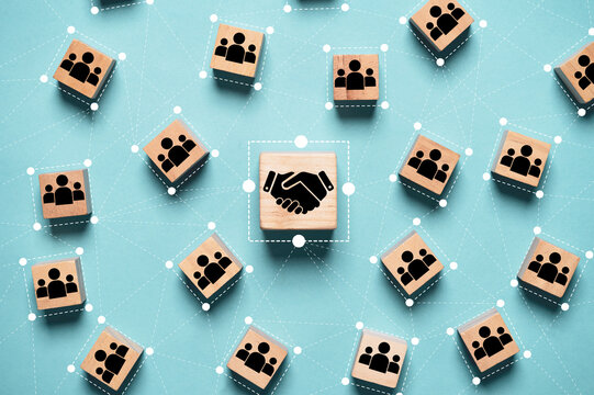Hand shaking icon print screen on wooden block cube and linkage with people icon for corporate and business deal agreement concept.