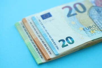 Big amount of one hundred, twenty and fifty euro money bills on blue background