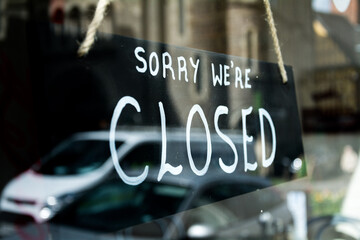 Sign in shop window says:  'Sorry we're closed'. Small high-street businesses on the decline in the...