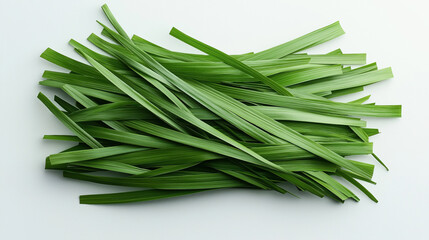 Fototapeta premium A neatly arranged stack of long, fresh green pandan leaves displayed on a plain light background.