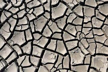 A riverbed dried up and cracked soil due to the lack of water and precipitation but also very high...