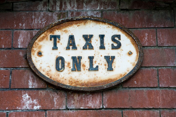 A rusty vintage sign saying, 'Taxis Only'. Found outside a train station in the UK.