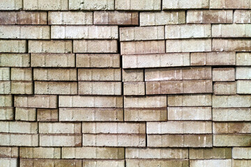Textured wall made of stacked concrete bricks in various shades of brown