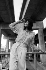 Black and white photo of a girl in classic clothes posing on the streets of Bangkok.