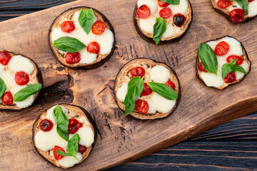 Italian mini pizza . Aubergine (eggplant ) with mozzarella cheese and basil . On rustic background