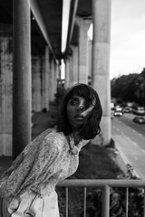 Black and white photo of a girl in classic clothes posing on the streets of Bangkok.