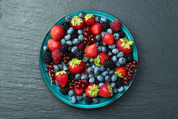 Mix of ripe colorful berries in bowl photography . Blueberry , strawberry , raspberry , blackberry and red currant . Top view