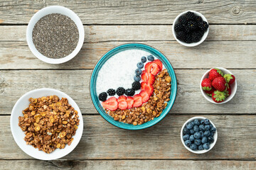 Healthy breakfast . Yogurt with berries ( strawberry , raspberry , blueberry , blackberry ) , granola and chia seeds . Top view