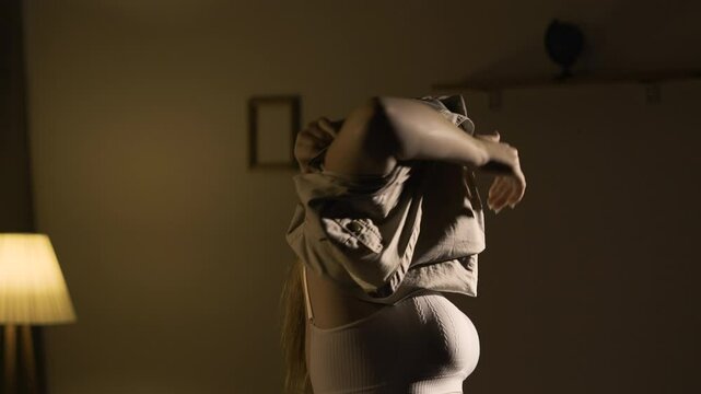 young woman putting on dress, preparing to go to walk in the evening, daily routine.