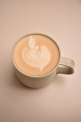 Minimalist coffee scene: a cup of cappuccino with smooth foam on a light table, capturing...
