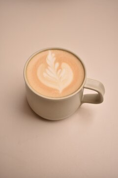 Freshly brewed cappuccino with delicate milk foam art, served on a bright table &mdash; a calm and cozy coffee moment.
