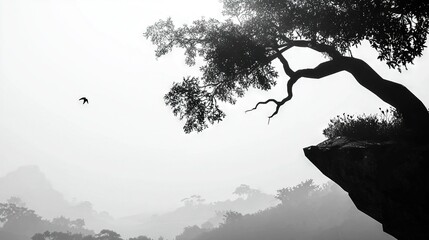 Naklejka premium A monochrome image depicts a tall tree perched atop a cliff, with a soaring bird visible against the blue sky