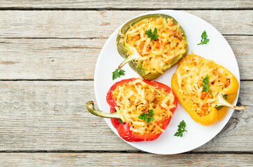 Baked stuffed pepper ( paprika ) with rice , carrot and meat . Top view on rustic background