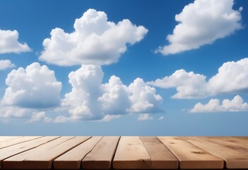 An empty wooden tabletop with blue skies and clouds is ideal for displaying merchandise