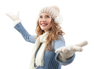 A cheerful and joyful woman, dressed in warm winter clothes, hat, scarf, sweater and gloves stands with open arms. Her face shines with happiness and excitement as dreams of a white Christmas holiday