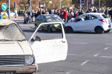 Heavily damaged cars after a collision at a busy intersection
