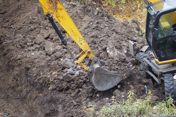 The excavator performs earthworks, creating a foundation for construction.