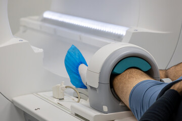  Knee MRI scan examination at clinic. Prepares the patient for an MRI knee examination