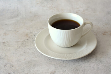 a cup of coffee sits on a saucer in the marble background 