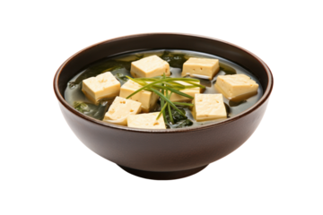 Miso soup in a traditional Japanese bowl with tofu cubes and seaweed floating on the surface isolated on white background