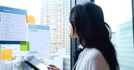 Woman, tablet and paper on window for business, presentation planning and information in Japanese office. Insurance broker, tech and reading in agency for policy checklist, research and storyboard