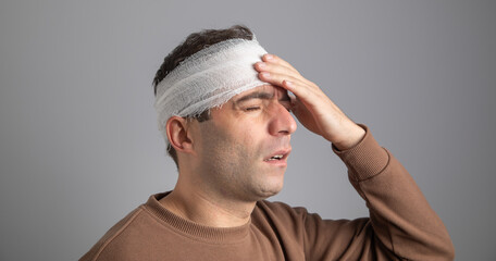 Caucasian man with a bandage on head.