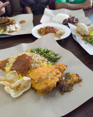Asian food known as Nasi Kerabu, a blue rice, serve with authentic traditional sauce, fried fish, steamed chilli, and some raw vegetables