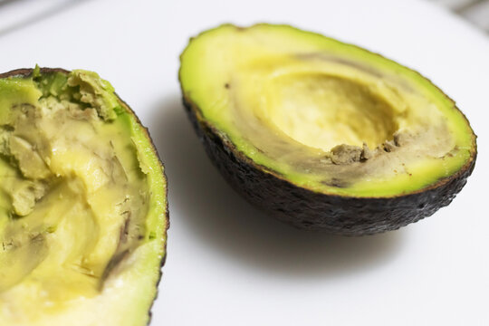 Avocados are rotten if they're mushy when squeezed, brown or moldy inside, and have developed rancidity or a sour smell.