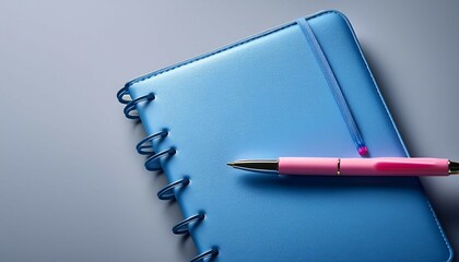 a blue notebook with a pink pen on top of it