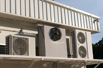 Air compressor or air condenser unit located on support outside building to heat released...