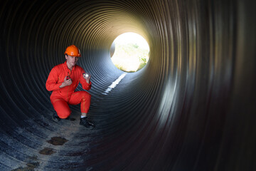 Male mechanical engineer wearing safety uniform inspects and inspects piping system of new...
