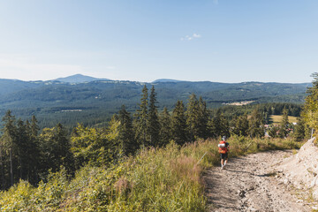 Explorer walk in the serene Beskydy Mountains, Czech Republic, surrounded by lush forests and rolling hills, capturing the allure of untouched nature and adventure