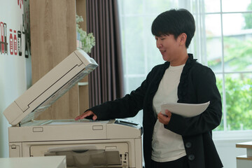 Office workers are using a photocopier.