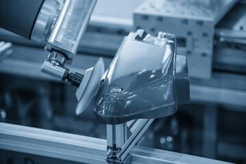 The automotive parts polishing process by robotic system in the light blue scene.