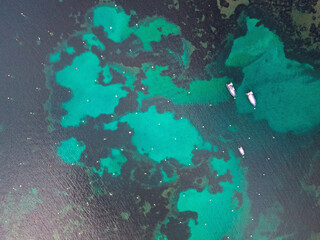 Aerial top down of rocks in blue water Mediterannean Sea along Costa Brava Palamos Catalonia