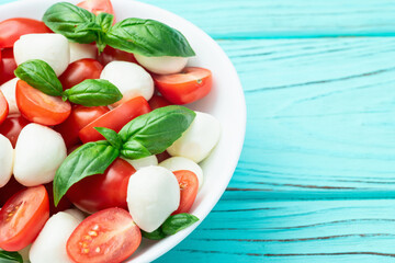 Basil leaves , cherry tomatoes and mozzarella cheese . In bowl food photography