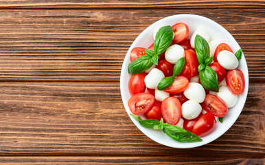 Basil leaves , cherry tomatoes and mozzarella cheese . In bowl food photography