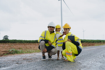 Engineer family in survey set father mother and son inspect and work on wind farm rotating to electricity renewable energy alternative for clean energy concept