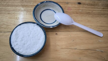 coconut milk custard in small porcelain cup (Thai dessert) in wooden dish on table.