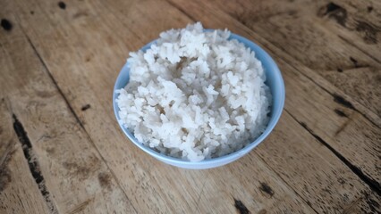 Rice in a blue bowl on a wooden table